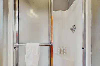 a bathroom with a shower with a white towel at Grizzly Peak Lodge in Granby