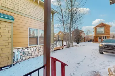 a house with snow on the ground next to a driveway at Grizzly Peak Lodge in Granby
