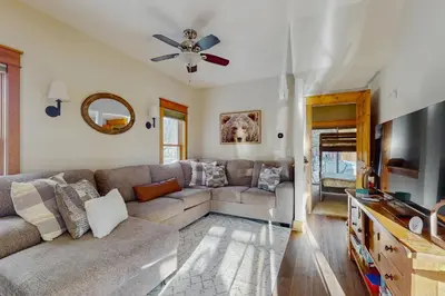 a living room with a couch and a ceiling fan at Grizzly Peak Lodge in Granby
