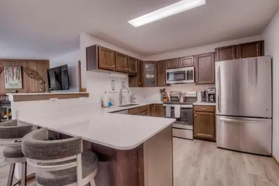 a kitchen with stainless steel appliances and wooden cabinets at Keystone Condo, Walking Distance to Ski Lift in Keystone