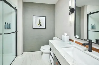 a bathroom with a tub and a toilet and a sink at Apiary Hotel Belleview Station in Denver