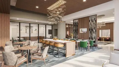 a restaurant with a bar and chairs and tables at Apiary Hotel Belleview Station in Denver