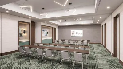 a conference room with a long table and chairs at Apiary Hotel Belleview Station in Denver