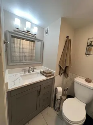 a bathroom with a sink and a toilet and a mirror at Stylish Stay In Downtown Denver in Denver