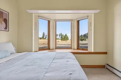 a bedroom with a large bed and large windows at Scenic Mountain Home, Media Room, TT, Gym in Boulder