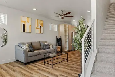 a living room with a couch and a staircase at Modern Retreat - Close to Old Town in Fort Collins