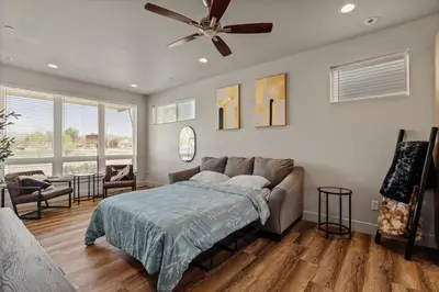 a bedroom with a couch and a ceiling fan at Modern Retreat - Close to Old Town in Fort Collins