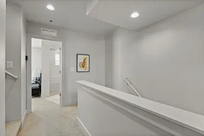 a hallway with white walls and a stair case at Modern Retreat - Close to Old Town in Fort Collins