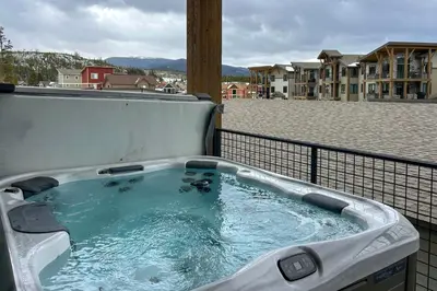 a hot tub on top of a balcony at Walk to Ski Shuttle and Brewery! New Fraser Condo in Fraser