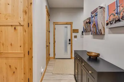 a kitchen with a black counter and a door at Walk to Ski Shuttle and Brewery! New Fraser Condo in Fraser