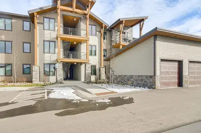 a large apartment building with a garage at Walk to Ski Shuttle and Brewery! New Fraser Condo in Fraser