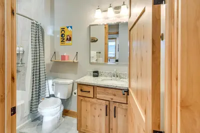 a bathroom with a toilet and a sink and a mirror at Walk to Ski Shuttle and Brewery! New Fraser Condo in Fraser