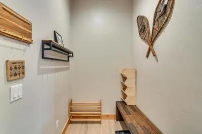 a room with a wooden bench next to a wall at Walk to Ski Shuttle and Brewery! New Fraser Condo in Fraser