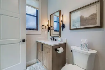 a bathroom with a toilet and a sink and a mirror at 37 Alcove townhouse in Keystone