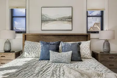 a bedroom with a bed with pillows and two lamps at 37 Alcove townhouse in Keystone