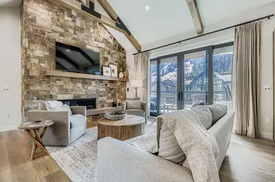 a living room with a couch and a stone wall at 37 Alcove townhouse in Keystone