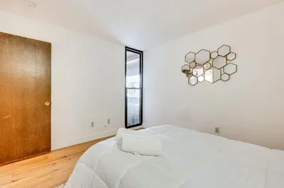 a white bedroom with a large bed and a window at 1 Mi to CU Boulder! Walkable Condo with Indoor Pool in Boulder