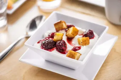 a white bowl of food with berries and whipped cream at Hyatt Place Denver Tech Center in Centennial