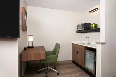 a kitchen with a desk and a chair and a sink at Hyatt Place Denver Tech Center in Centennial