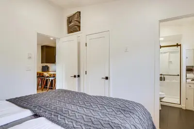 a white bedroom with a bed and a bathroom at New Luxury Modern Riverside Scandinavian Cabin in Breckenridge