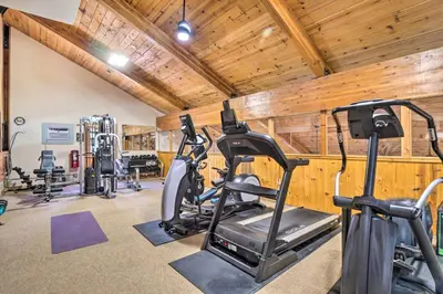 a gym with several treadmills and exercise bikes at New Luxury Modern Riverside Scandinavian Cabin in Breckenridge