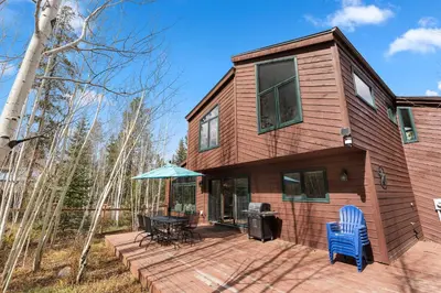 a wooden house with a table and chairs on a deck at Keystone Gulch - Near Keystone Resort & Golf in Keystone