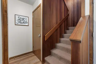 a hallway with a staircase with a wooden door and a stair mitzev sign at Keystone Gulch - Near Keystone Resort & Golf in Keystone