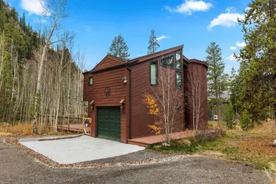 a house with a green garage in the woods at Keystone Gulch - Near Keystone Resort & Golf in Keystone