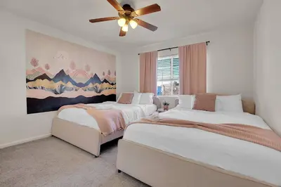 two beds in a bedroom with a ceiling fan at Modern Luxe Stay • Bright & Photo-Ready in Westminster