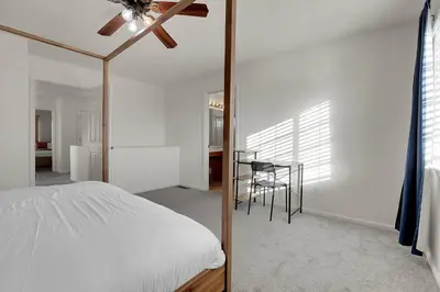 a bedroom with a bed with a ceiling fan and a table at Modern Luxe Stay • Bright & Photo-Ready in Westminster