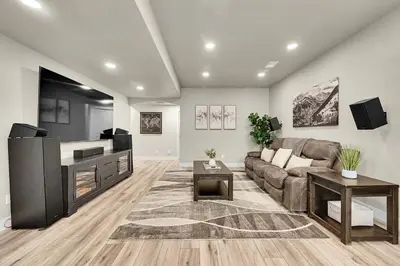 a living room with a couch and a flat screen tv at Modern 5BR/3BA Luxury Home|Movie Nights & Comfort in Evans