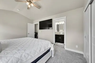 a white bedroom with a bed and a ceiling fan at Modern 5BR/3BA Luxury Home|Movie Nights & Comfort in Evans