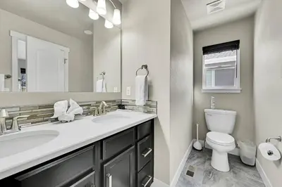 a bathroom with a sink and a toilet and a mirror at Modern 5BR/3BA Luxury Home|Movie Nights & Comfort in Evans