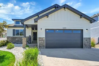 a white house with a garage at Modern 5BR/3BA Luxury Home|Movie Nights & Comfort in Evans