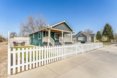 a blue house with a white picket fence at Kanons Kottage Downtown Retreat Near RMNP in Loveland