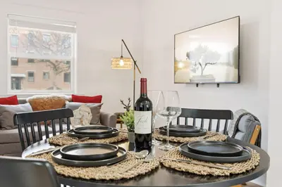 a dining room table with a bottle of wine and glasses at Mathews House with 4 King Beds Near CSU and Old Town in Fort Collins