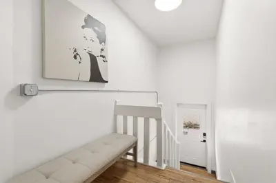 a white staircase with a bench and a picture on the wall at Mathews House with 4 King Beds Near CSU and Old Town in Fort Collins
