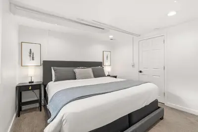 a white bedroom with a large bed and a white door at Mathews House with 4 King Beds Near CSU and Old Town in Fort Collins