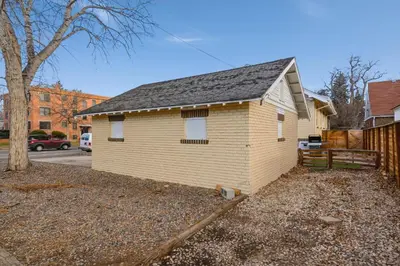 a small yellow house with a black roof at Mathews House with 4 King Beds Near CSU and Old Town in Fort Collins