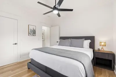 a bedroom with a large bed with a ceiling fan at Mathews House with 4 King Beds Near CSU and Old Town in Fort Collins