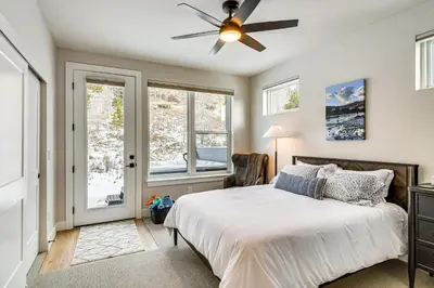 a bedroom with a bed and a ceiling fan at Saltwater Hot Tub! Unit Near Winter Park Slopes in Fraser