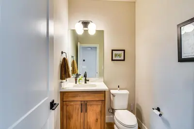 a bathroom with a sink and a toilet and a mirror at Saltwater Hot Tub! Unit Near Winter Park Slopes in Fraser