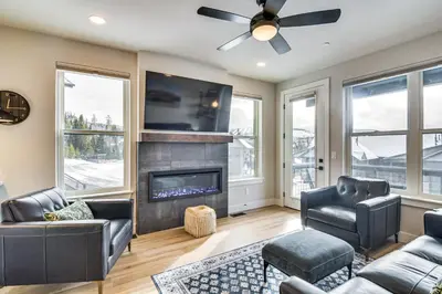 a living room with a fireplace and a ceiling fan at Saltwater Hot Tub! Unit Near Winter Park Slopes in Fraser