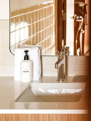 a bathroom sink with a bottle of soap on it at La Vista Motel in Denver