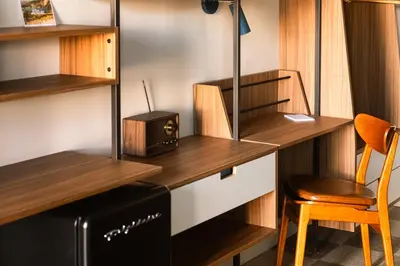 a room with a desk with a microwave and a chair at La Vista Motel in Denver
