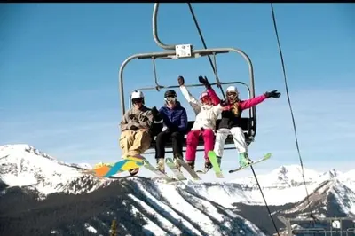 a group of people sitting on a ski lift at King Suite Between City and Slopes in Denver