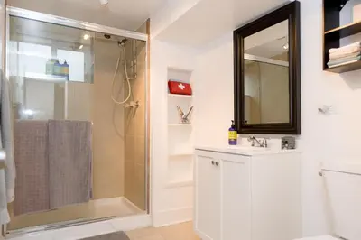 a bathroom with a shower and a sink and a mirror at King Suite Between City and Slopes in Denver