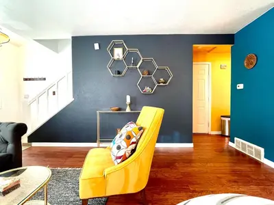 a yellow chair in a room with a blue wall at Townhome with Dedicated Workspace, WIFI, Garage in Lakewood