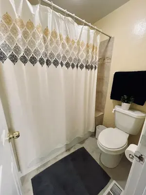a bathroom with a toilet and a shower curtain at Townhome with Dedicated Workspace, WIFI, Garage in Lakewood
