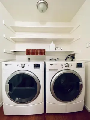 two washing and drying machines in a room at Townhome with Dedicated Workspace, WIFI, Garage in Lakewood